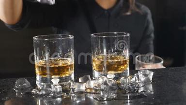 冰块掉进威士忌的玻璃杯里。 酒保的概念。 慢动作。 冰掉了。 高清高清